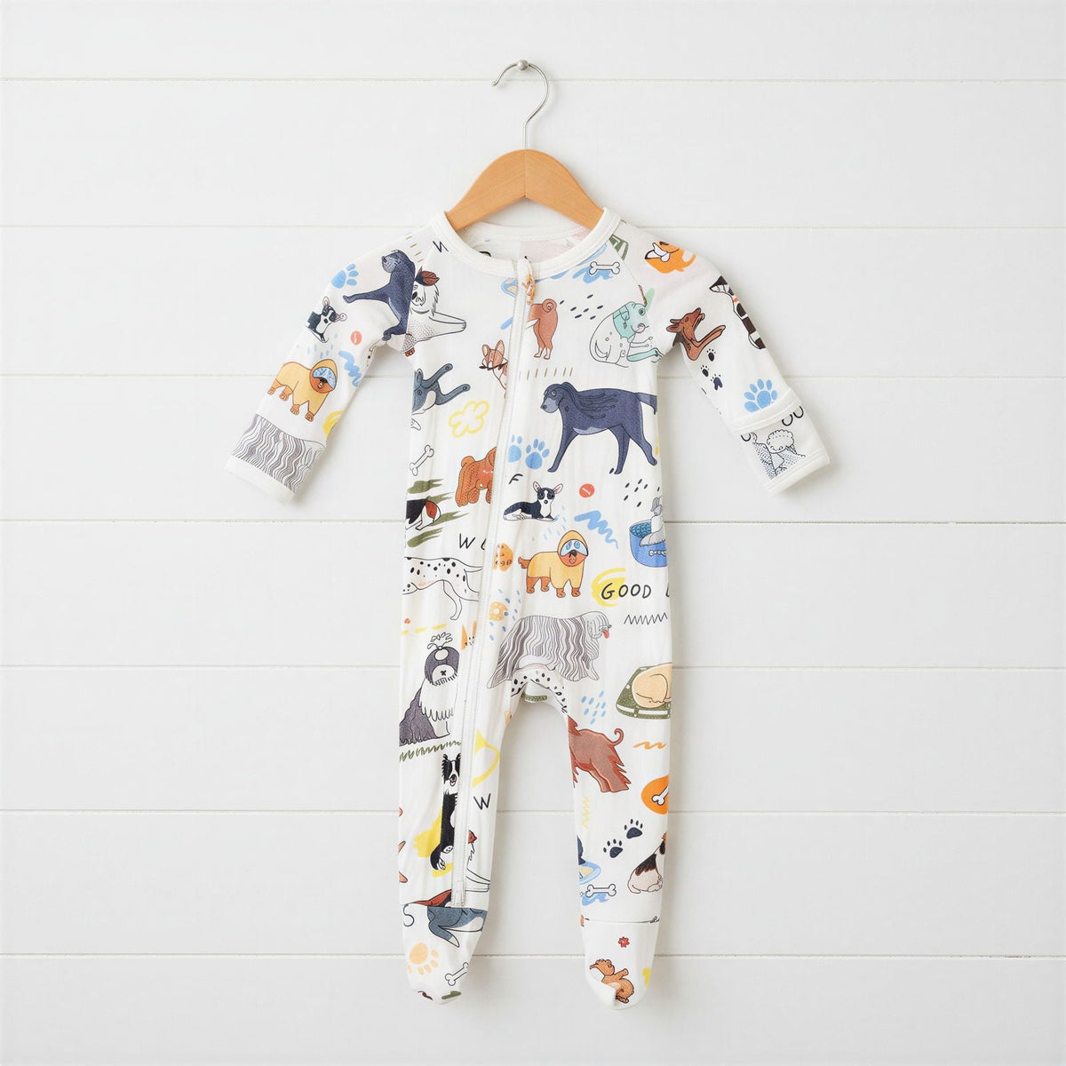White baby footie pajama with an all-over puppy dog print and full-length zipper