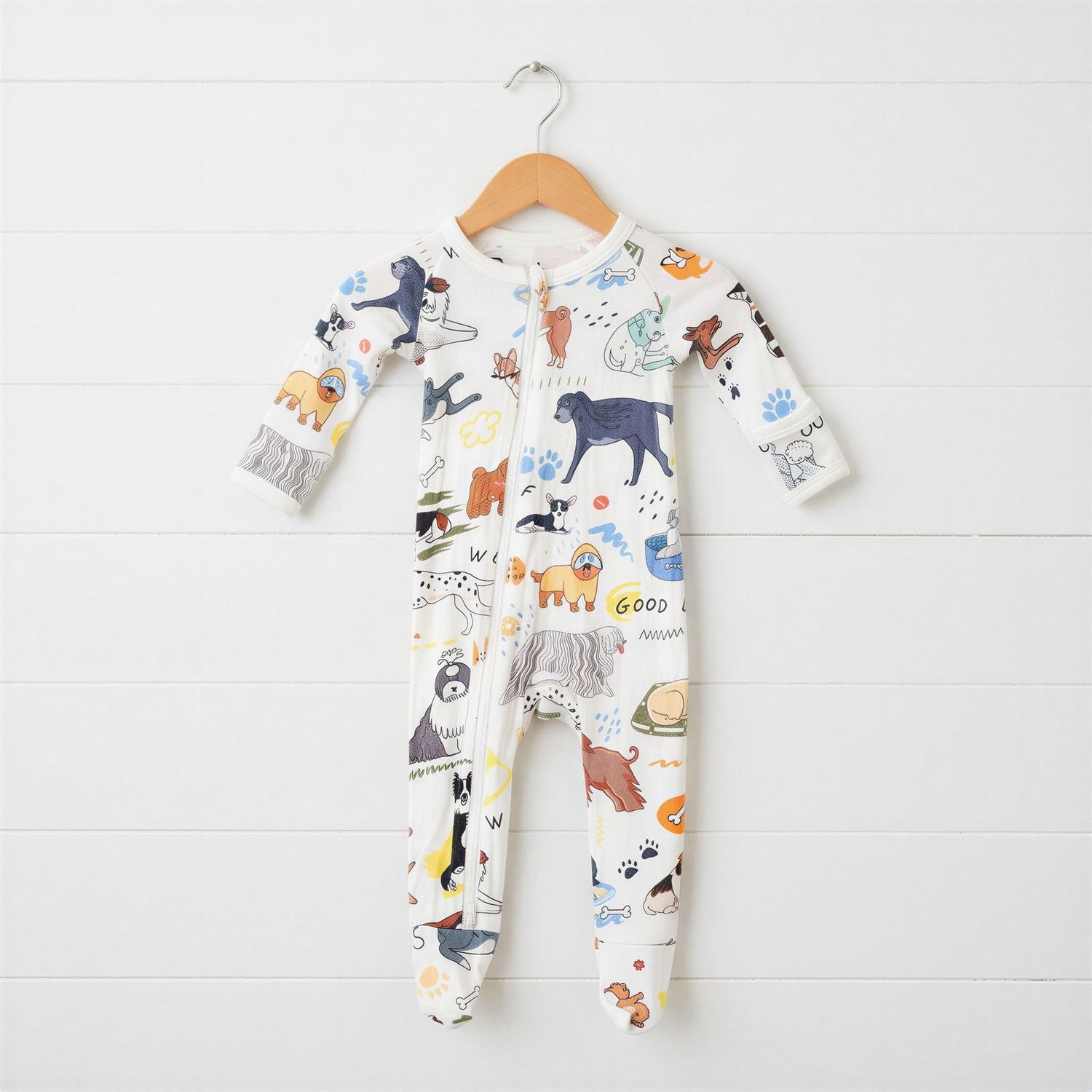 White baby footie pajama with an all-over puppy dog print and full-length zipper