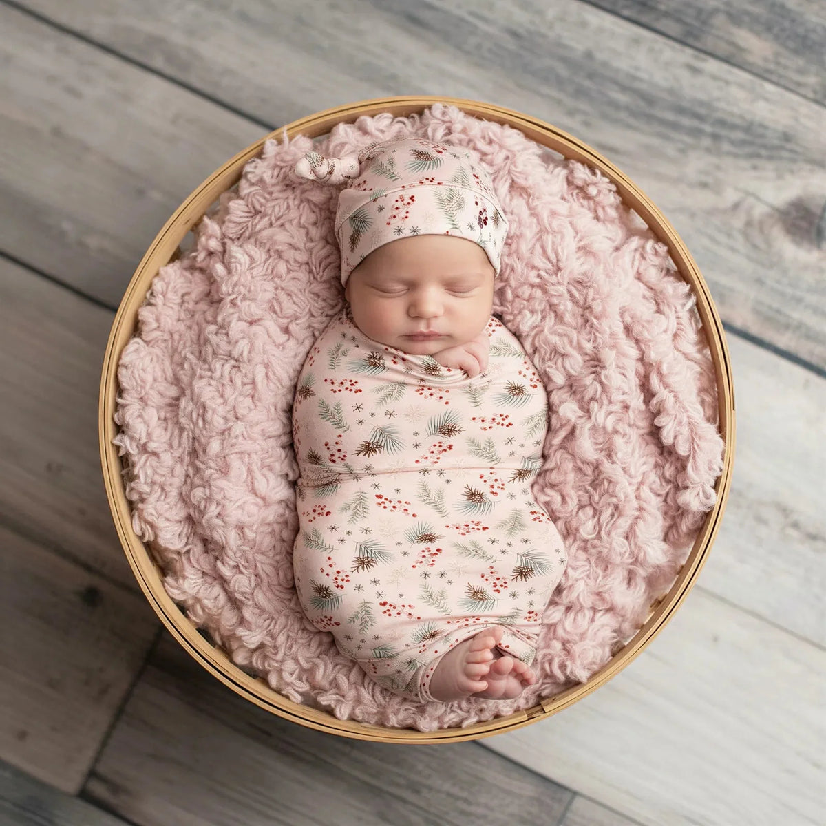 Cozy Pines swaddle blanket with a pink pine tree pattern, spread flat