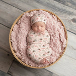 Cozy Pines swaddle blanket with a pink pine tree pattern, spread flat