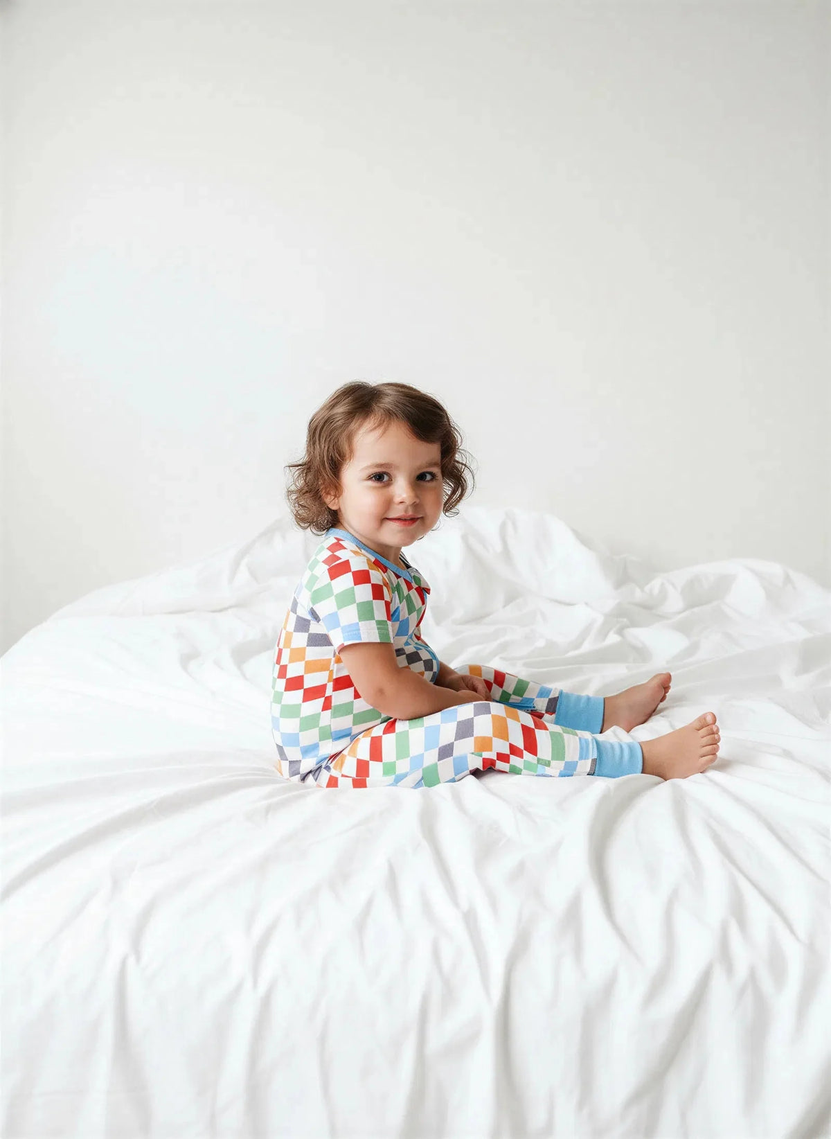 Baby coverall in a bold checkered print with a full-length 2-way zipper and long sleeves.