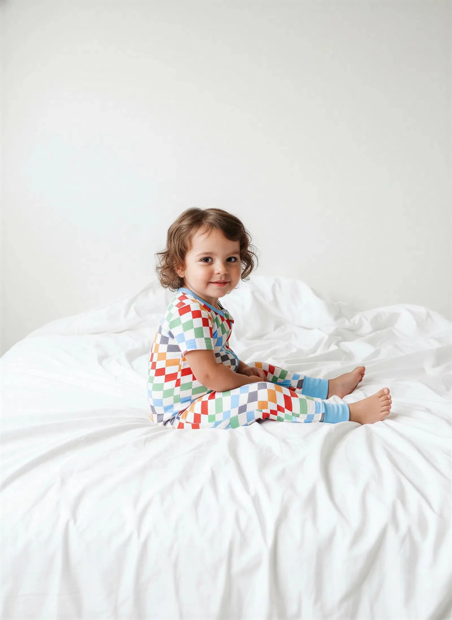 Baby coverall in a bold checkered print with a full-length 2-way zipper and long sleeves.