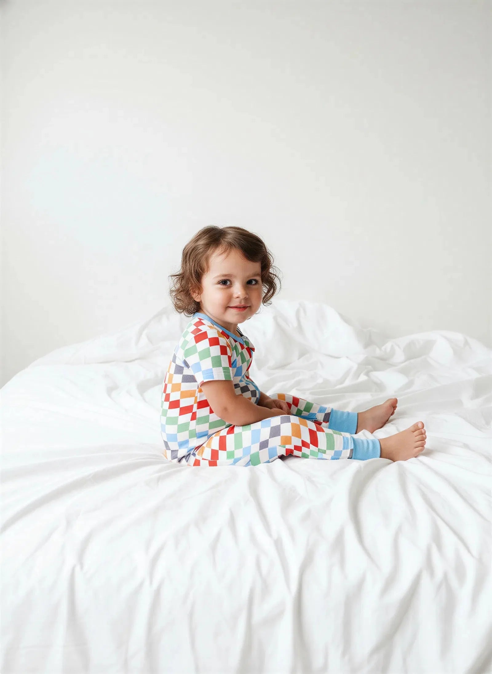 Baby coverall in a bold checkered print with a full-length 2-way zipper and long sleeves.