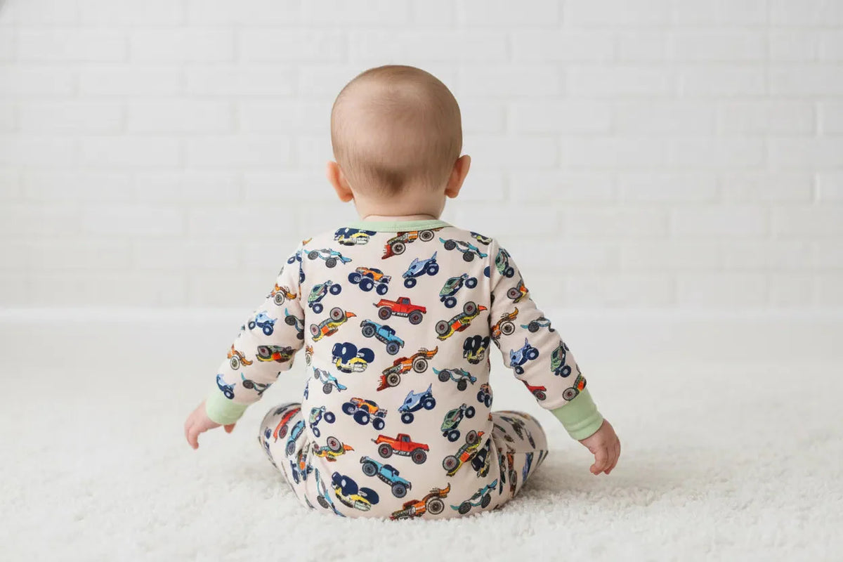 Baby footie pajamas in a wild wheels car print with a full-length front zipper and footed legs