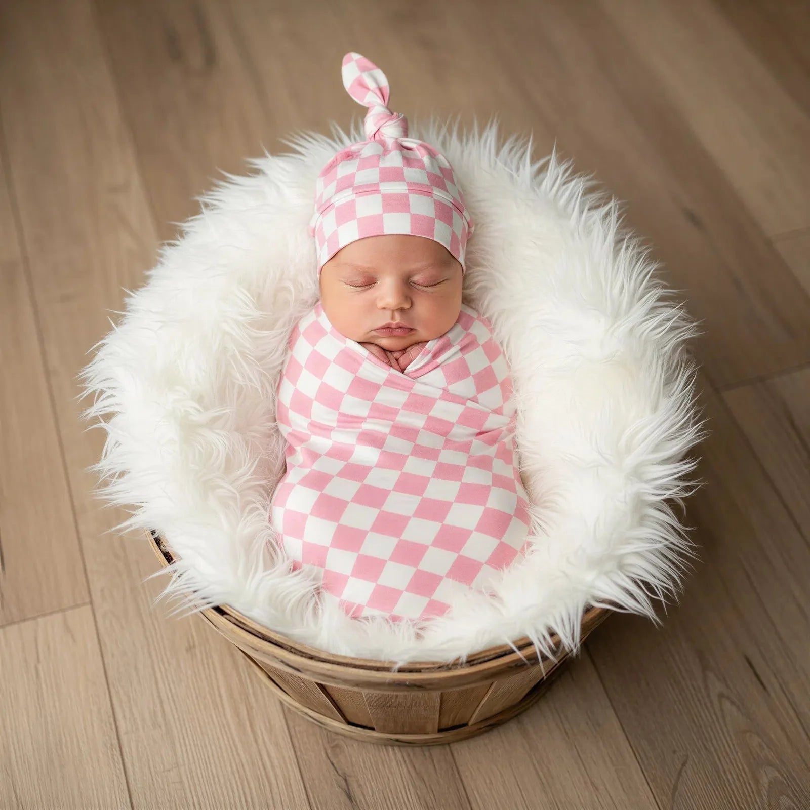 Pink checkered swaddle blanket in a soft bamboo fabric, folded to show the check pattern.
