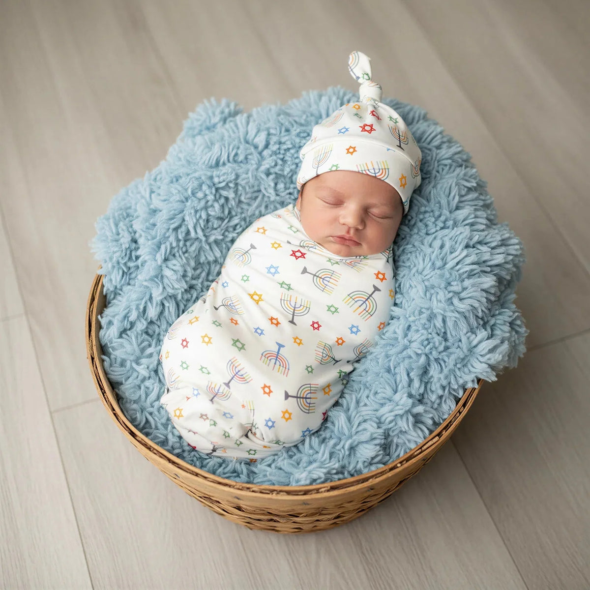 Happy Hanukkah swaddle blanket with festive Hanukkah-themed print, spread flat to show the square shape