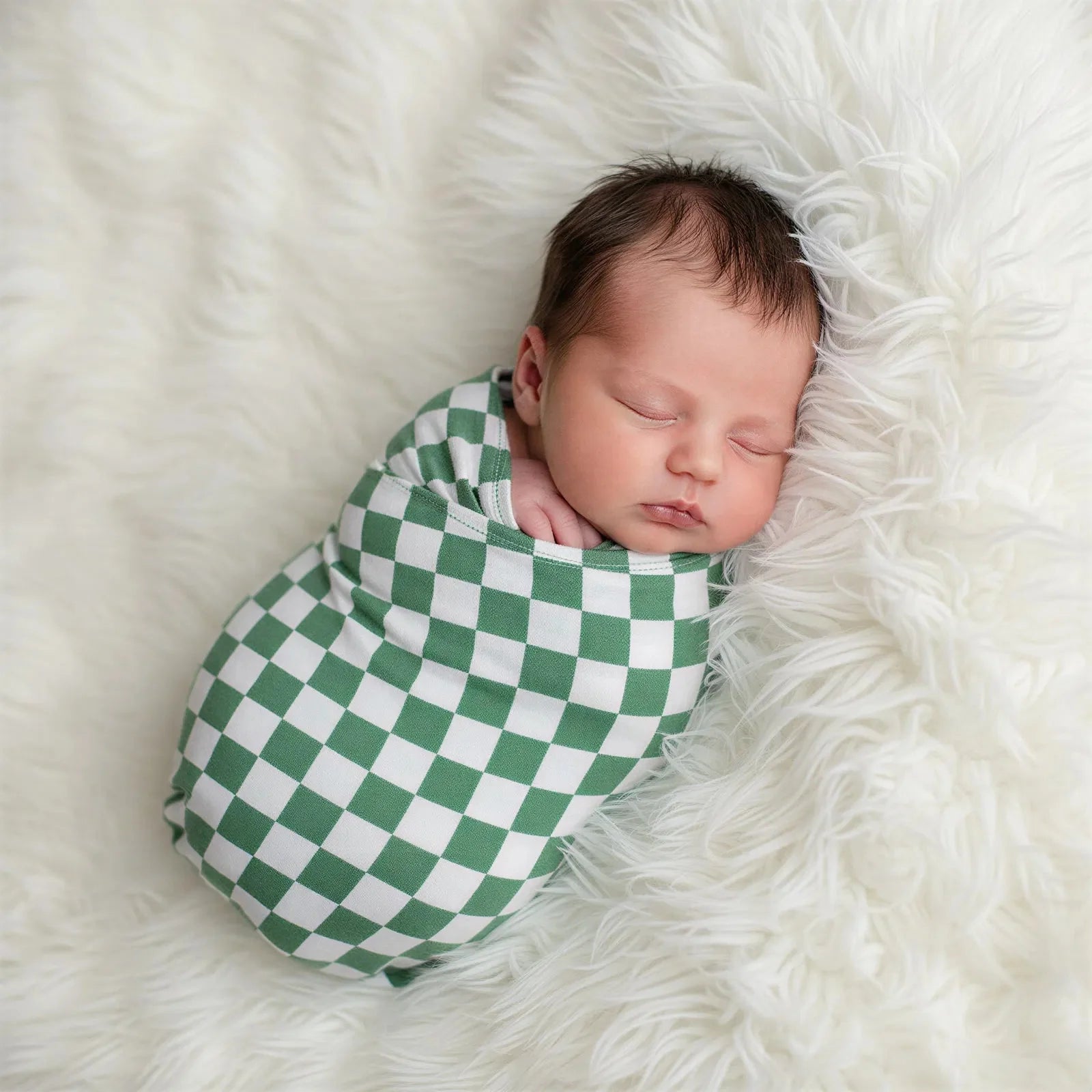 Swaddle blanket in emerald green and white check pattern, laid out flat