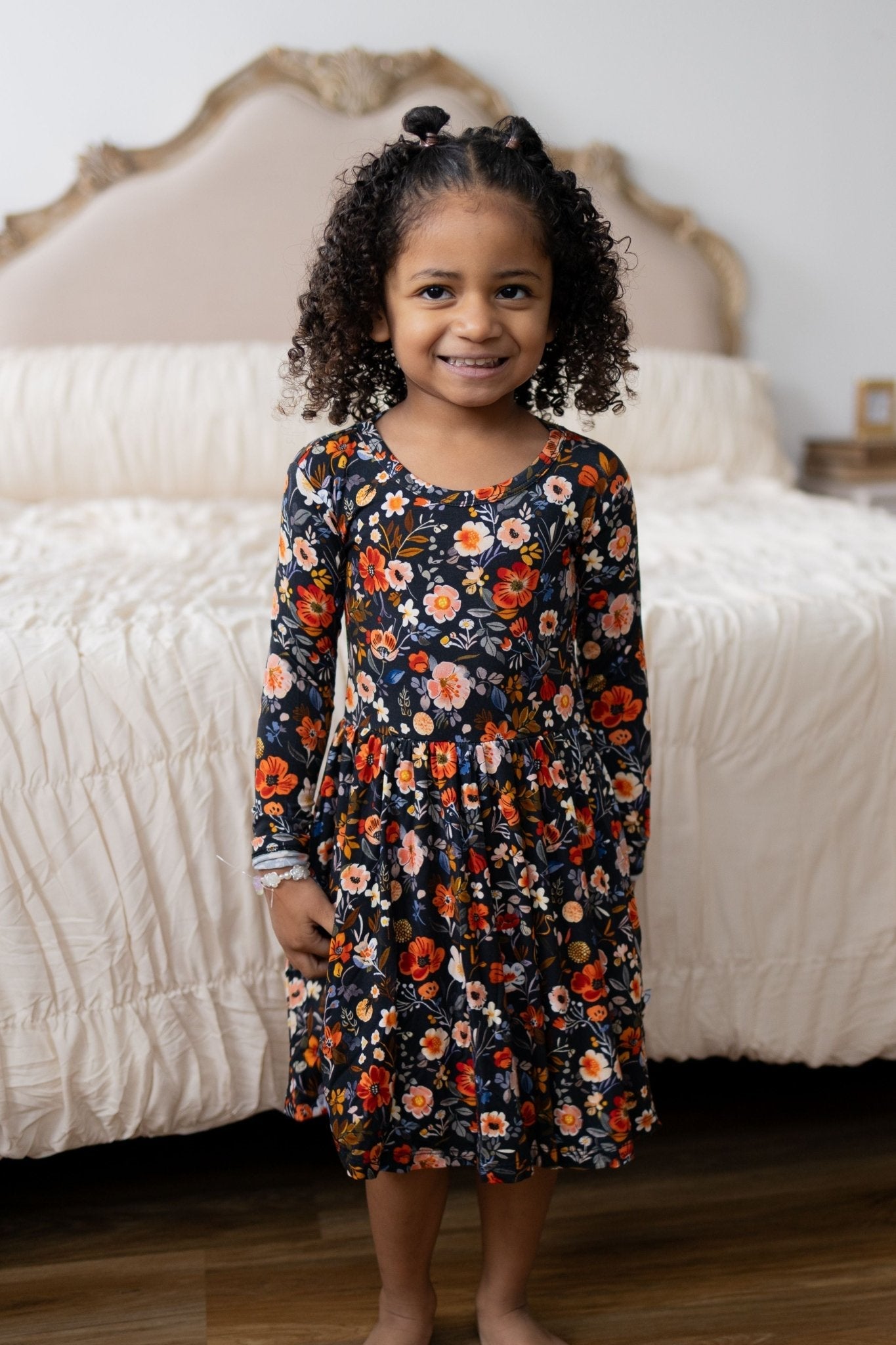 Long-sleeve navy twirl dress with autumn-hued floral print and peach trim, full flowy skirt.