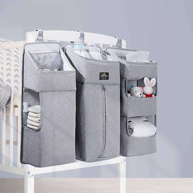 Baby Diaper Caddy with Dividers hanging on crib, multiple pockets for organizing baby essentials.