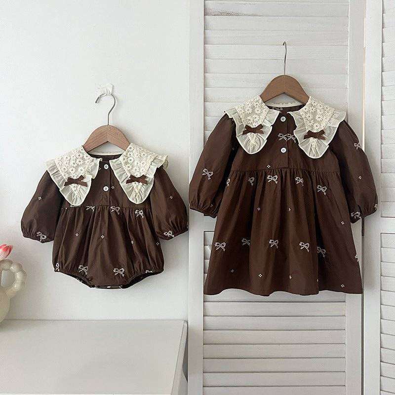 Girls long sleeves shirt with bows embroidery pattern displayed on hangers.