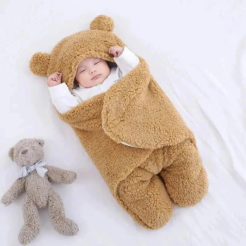 Baby wrapped in plush Berber fleece sleeping bag with bear ears, next to a teddy bear, offering warmth and comfort.