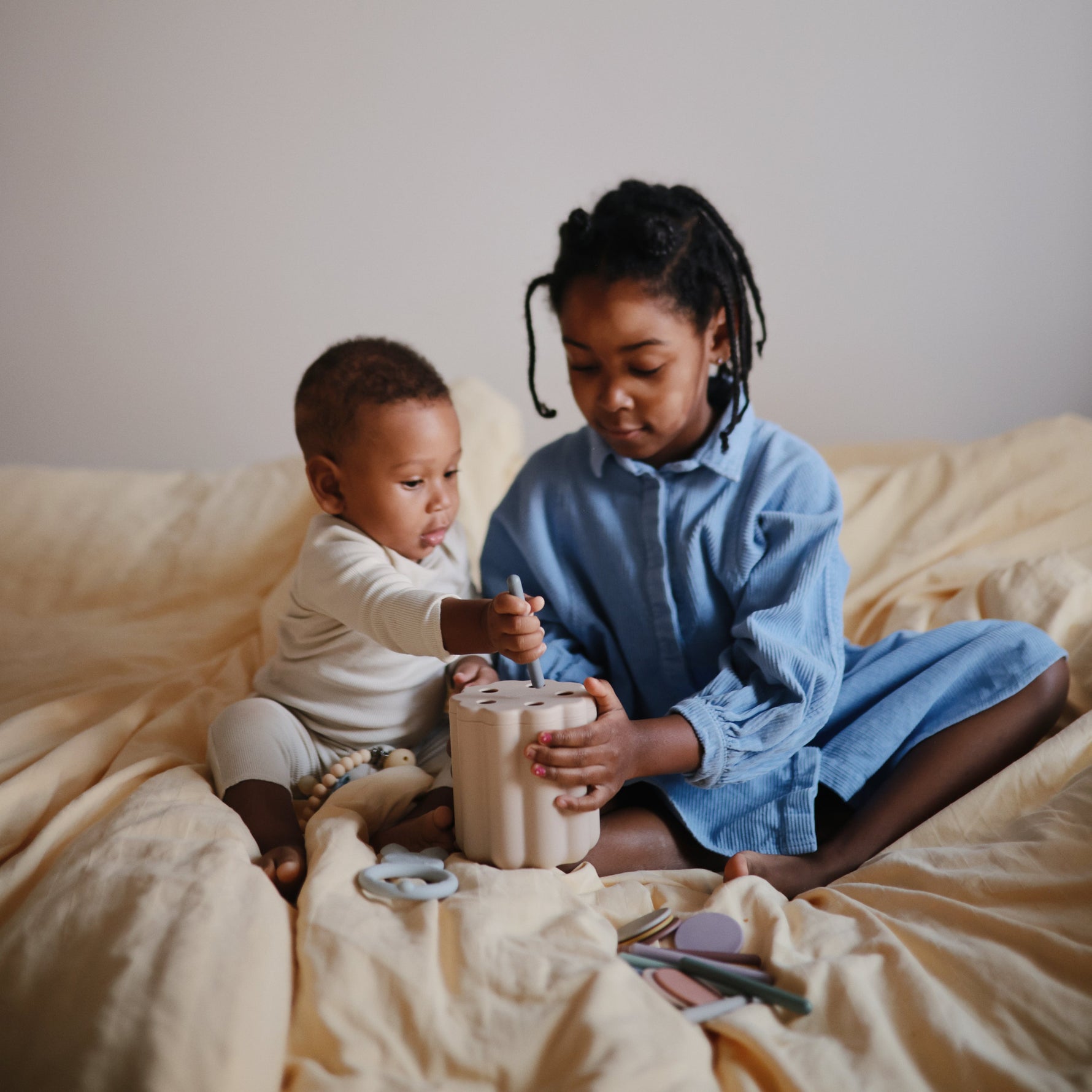 Mushie Coin & Tube Sorting Set. Bright, educational toy for fine motor development.