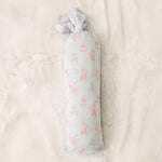 Pink ballerina-print baby swaddle blanket spread out flat in a square shape.