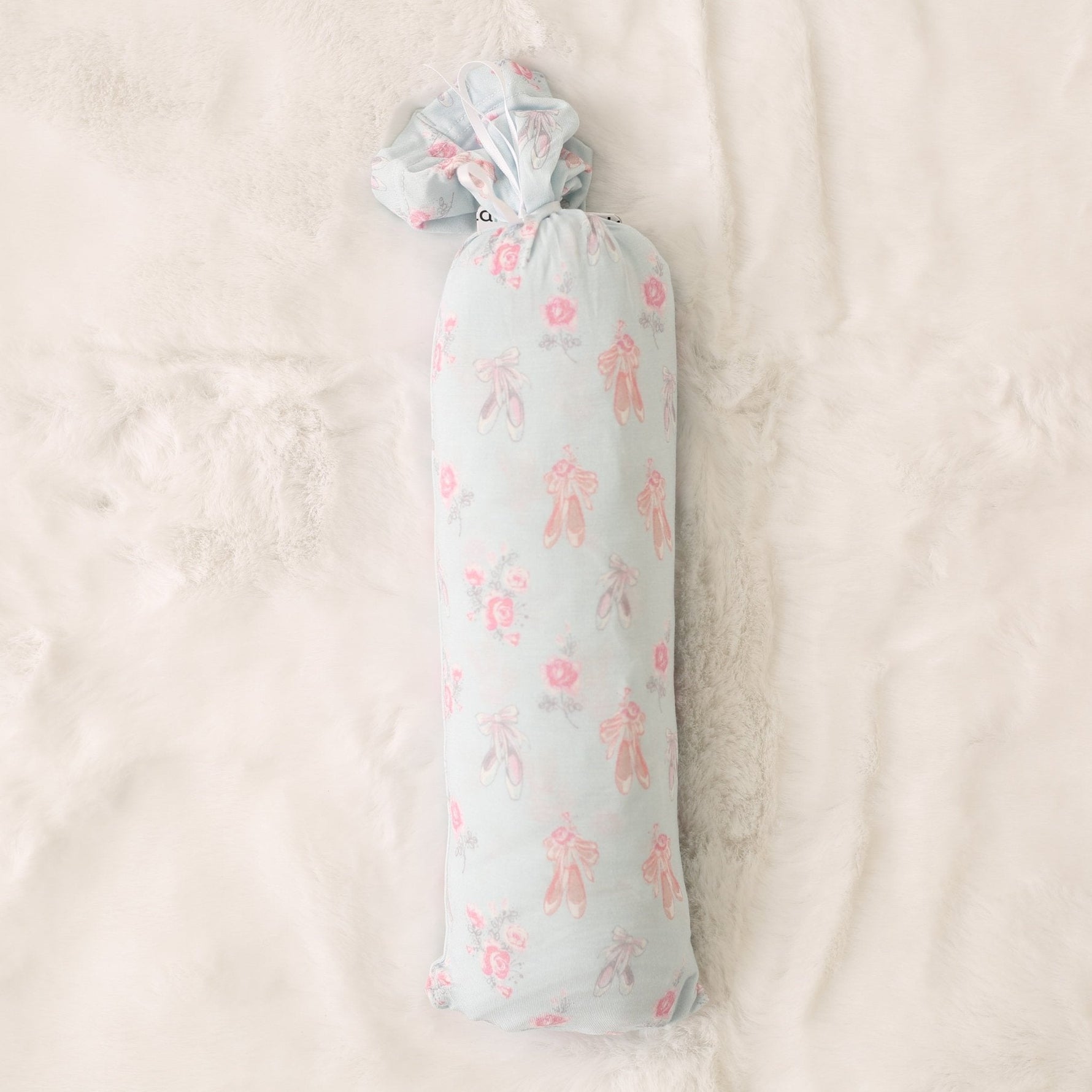 Pink ballerina-print baby swaddle blanket spread out flat in a square shape.