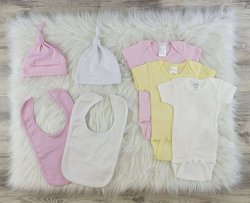 Unisex 7 Pc Layette with bodysuits, hats, and bibs in pink, yellow, and white on fluffy background.