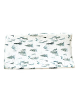 Soft organic bamboo changing pad cover in a green forest print, draped over a changing pad.