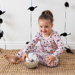 Long-sleeve two-piece pajama set with pink bows and polka dots on a toddler