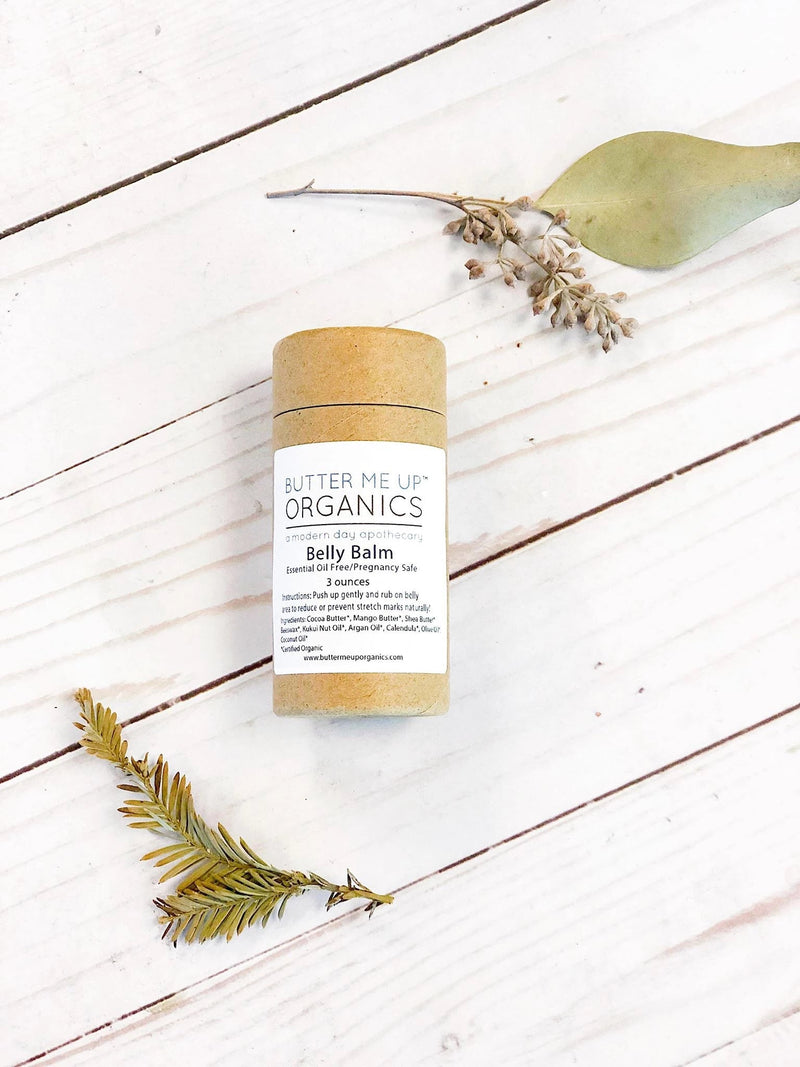 Organic pregnancy balm in compostable tube on white background with leaves.