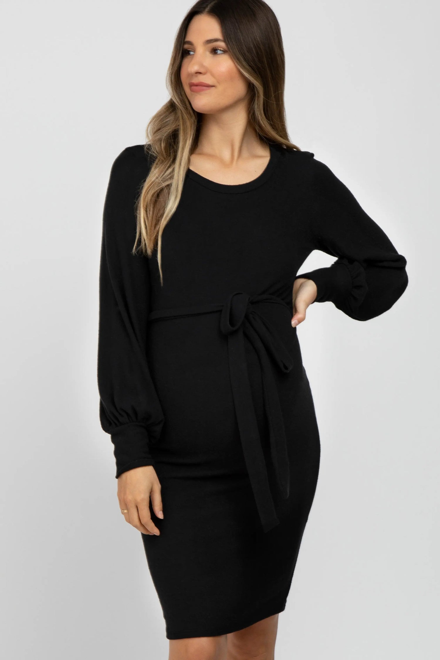 Black maternity dress with rounded neckline, long bubble sleeves, and an adjustable waist tie.