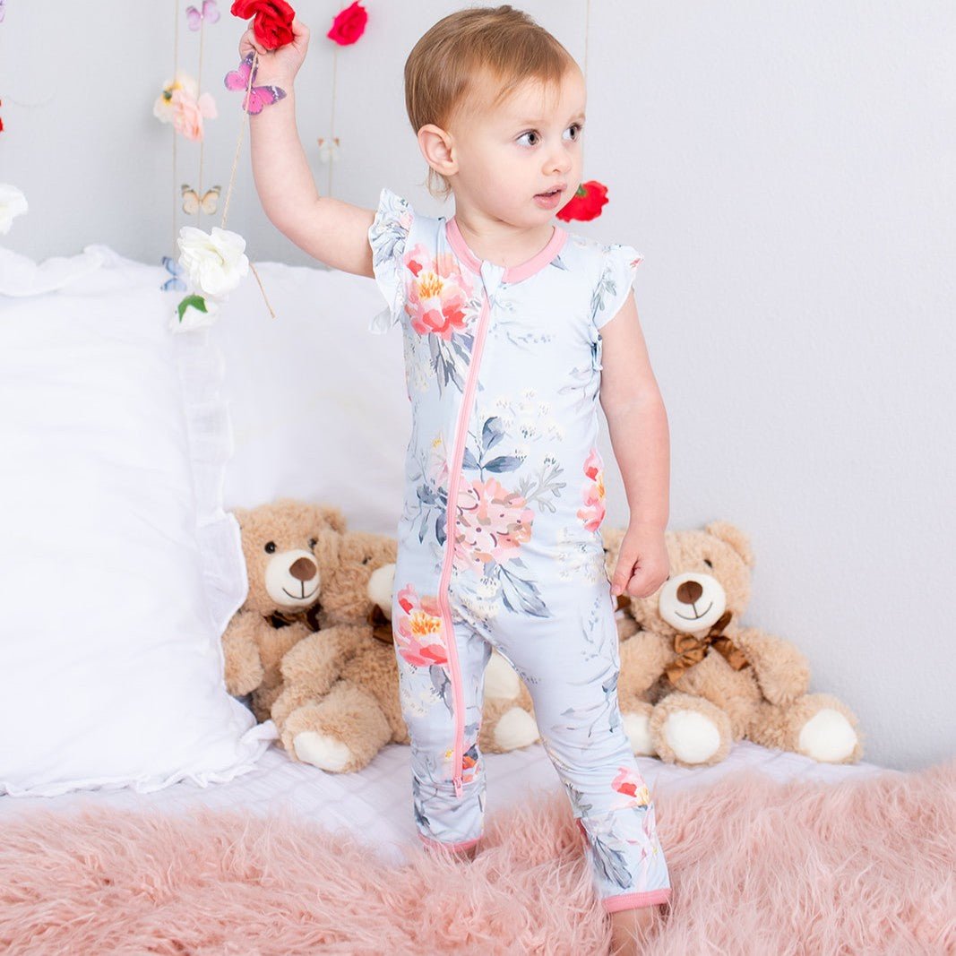 Pink flutter sleeve baby romper coverall with dual front zippers, shown on a baby with a teddy bear.