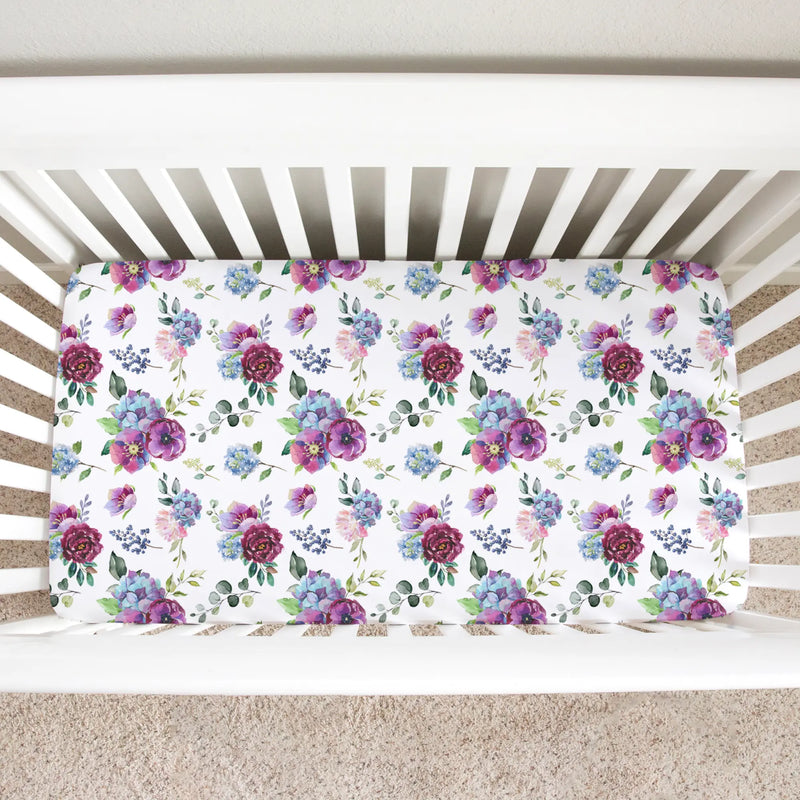 Blue floral fitted crib sheet in a standard size crib, showcasing soft, unique patterns for photography.