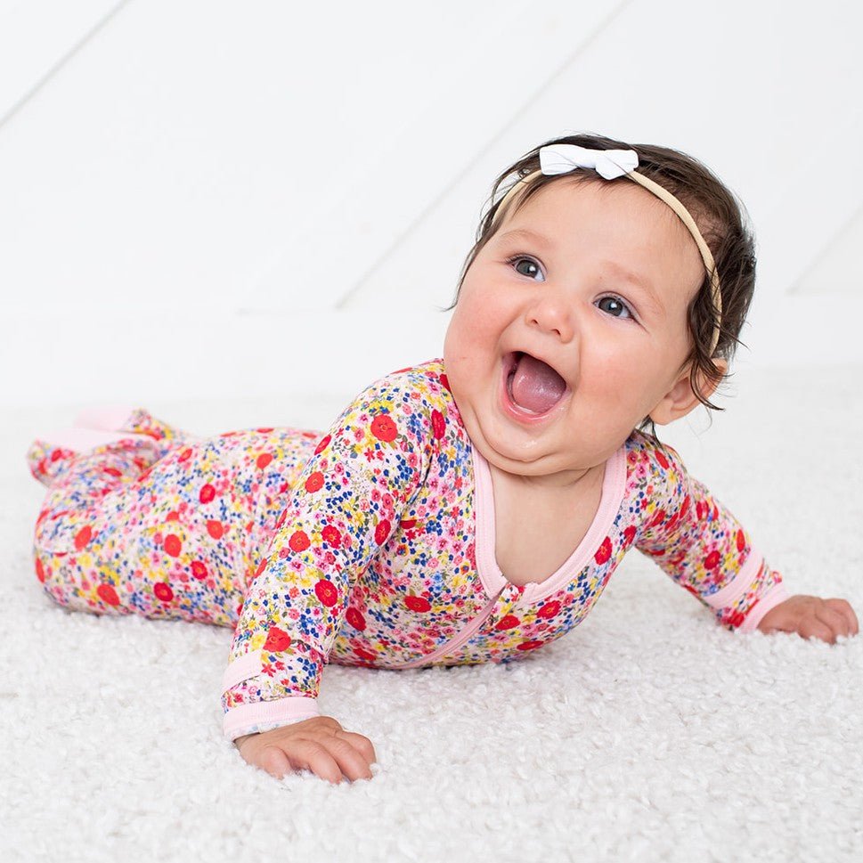Blush pink baby footie pajamas with covered feet and a full-length front zipper