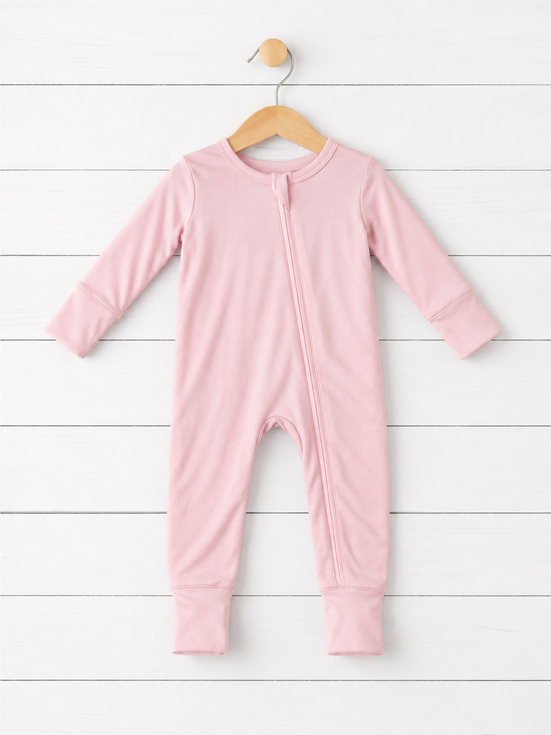 Baby convertible coverall in solid blush pink with long sleeves, full-length two-way zipper, and convertible feet