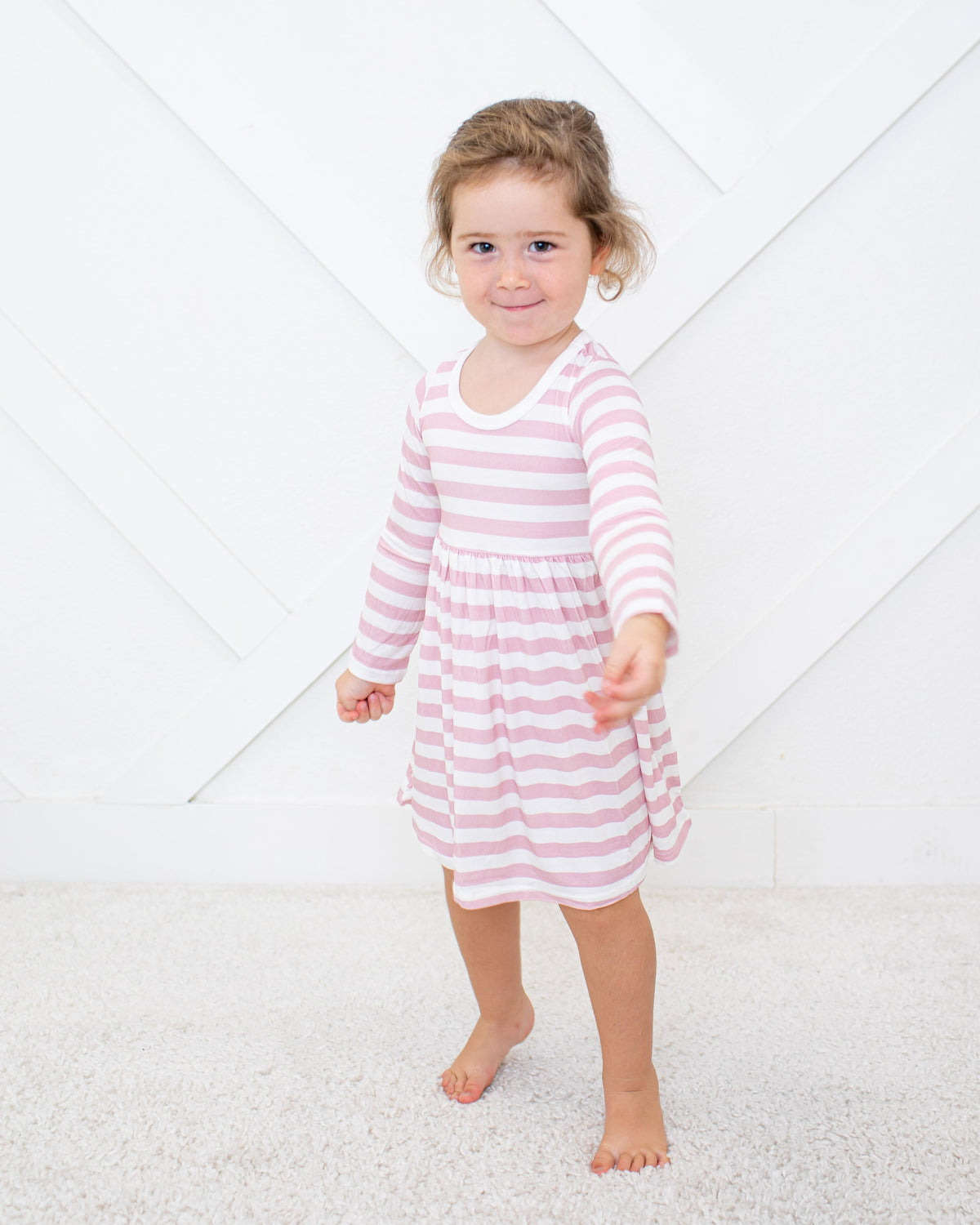 Long sleeve toddler dress in blush and white stripes with a full twirl skirt