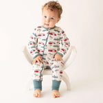 Baby coverall with a skateboard and bus print, dual zipper front and cuffed ankles.
