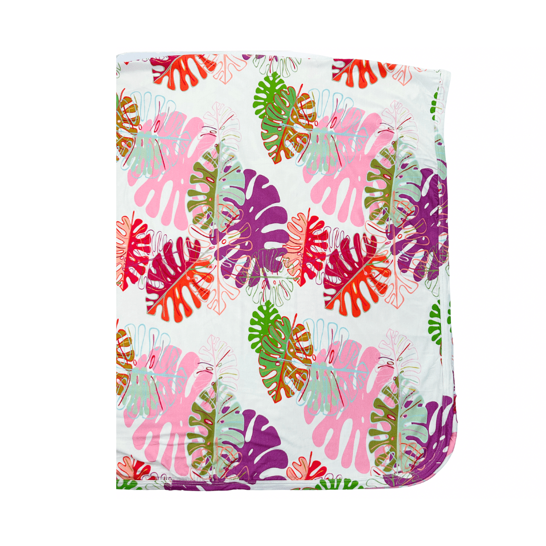 Swaddle blanket with pink botanical Swiss cheese plant leaf print, spread out flat