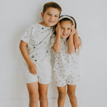 Finn + Emma organic baby shorts in natural white with a playful red crab print.