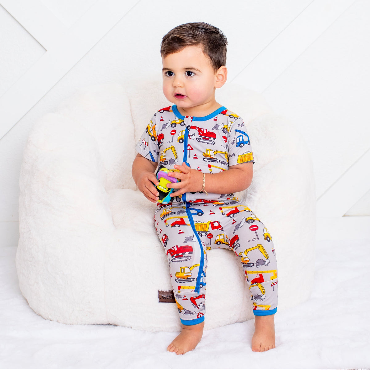 Baby convertible romper with a construction builders print and a two-way front zipper