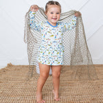 Bodysuit dress with long sleeves and a colorful fall fish print, worn by a smiling child.