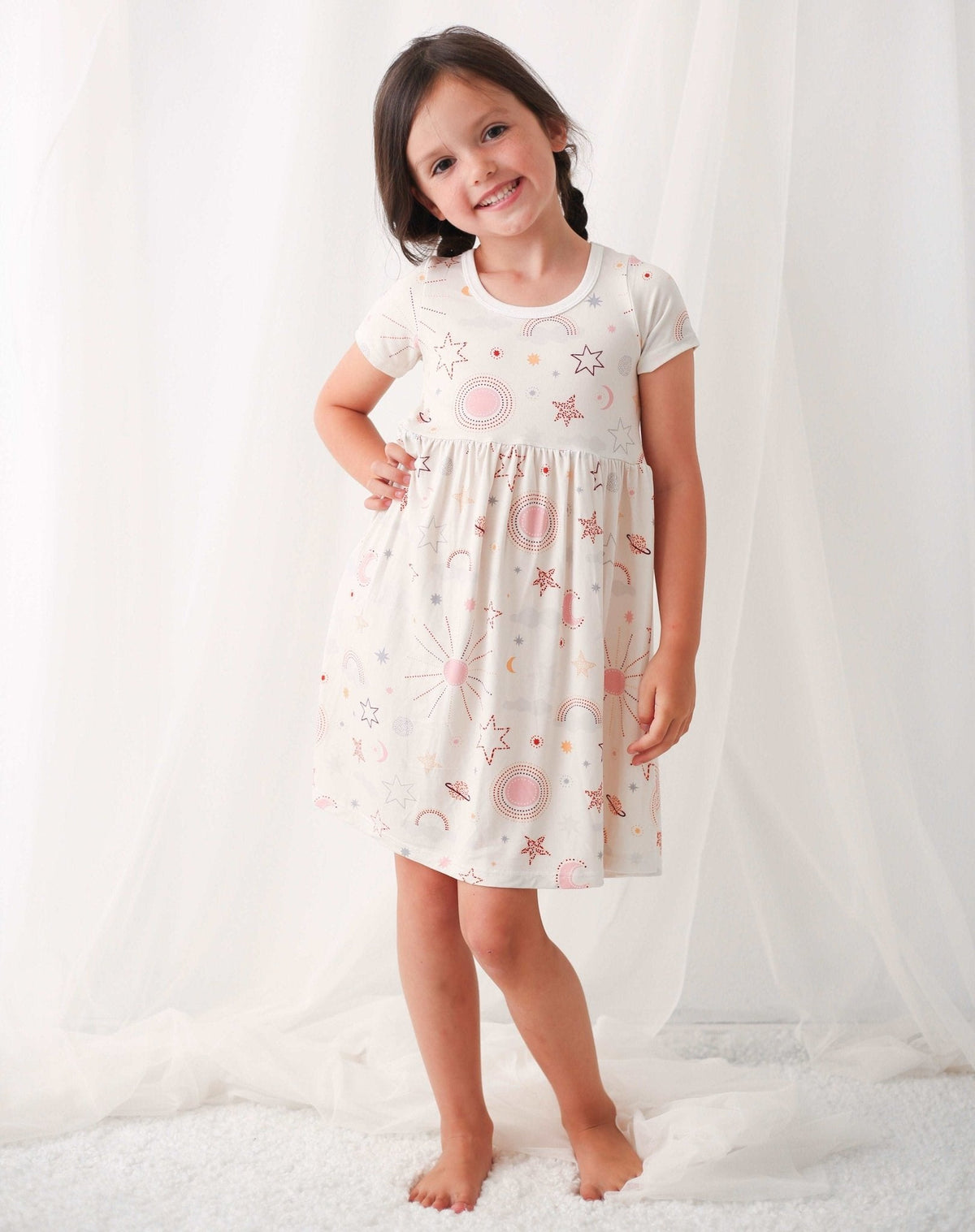 Celestial baby dress in soft pink, twirl-friendly skirt, worn by a young child