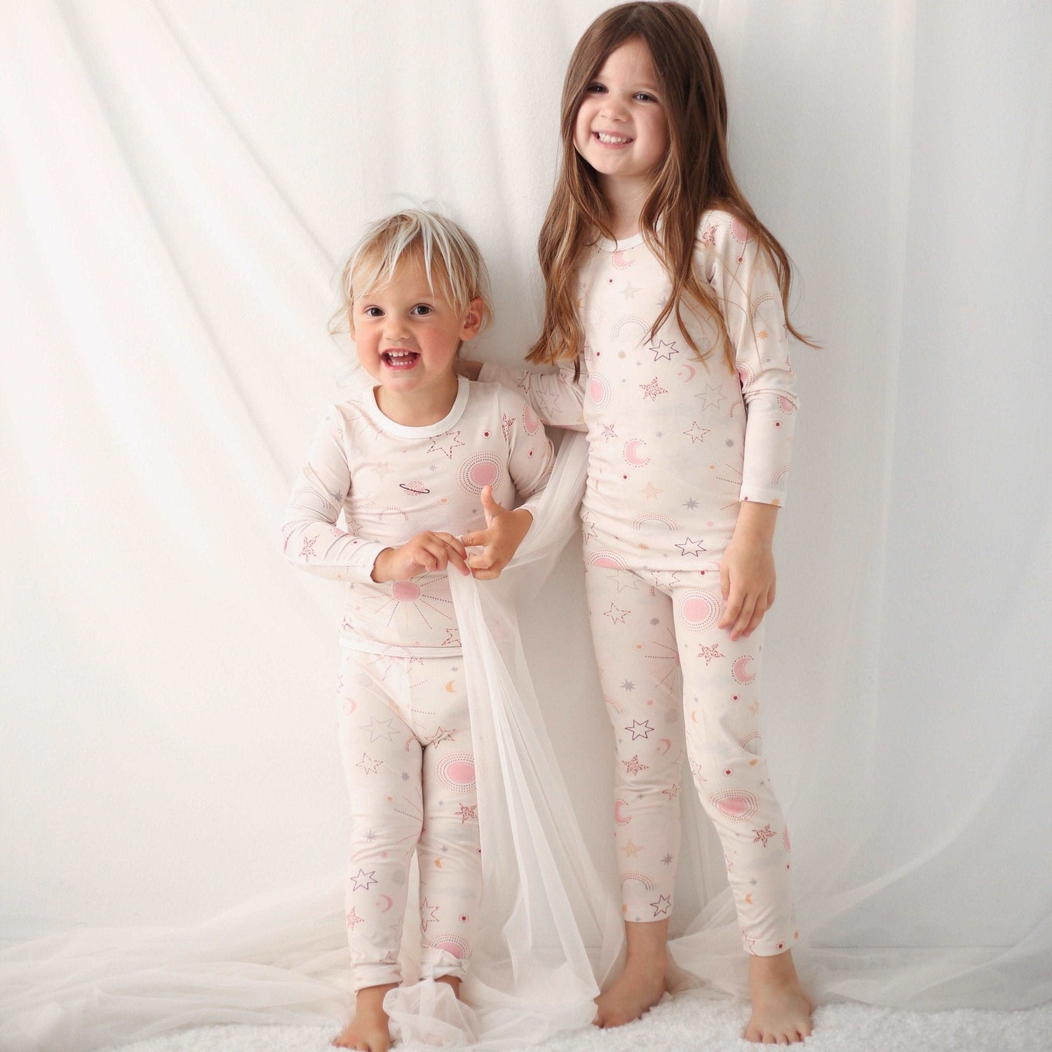 Two-piece baby pajama set with a celestial star and moon print on the top and matching pants