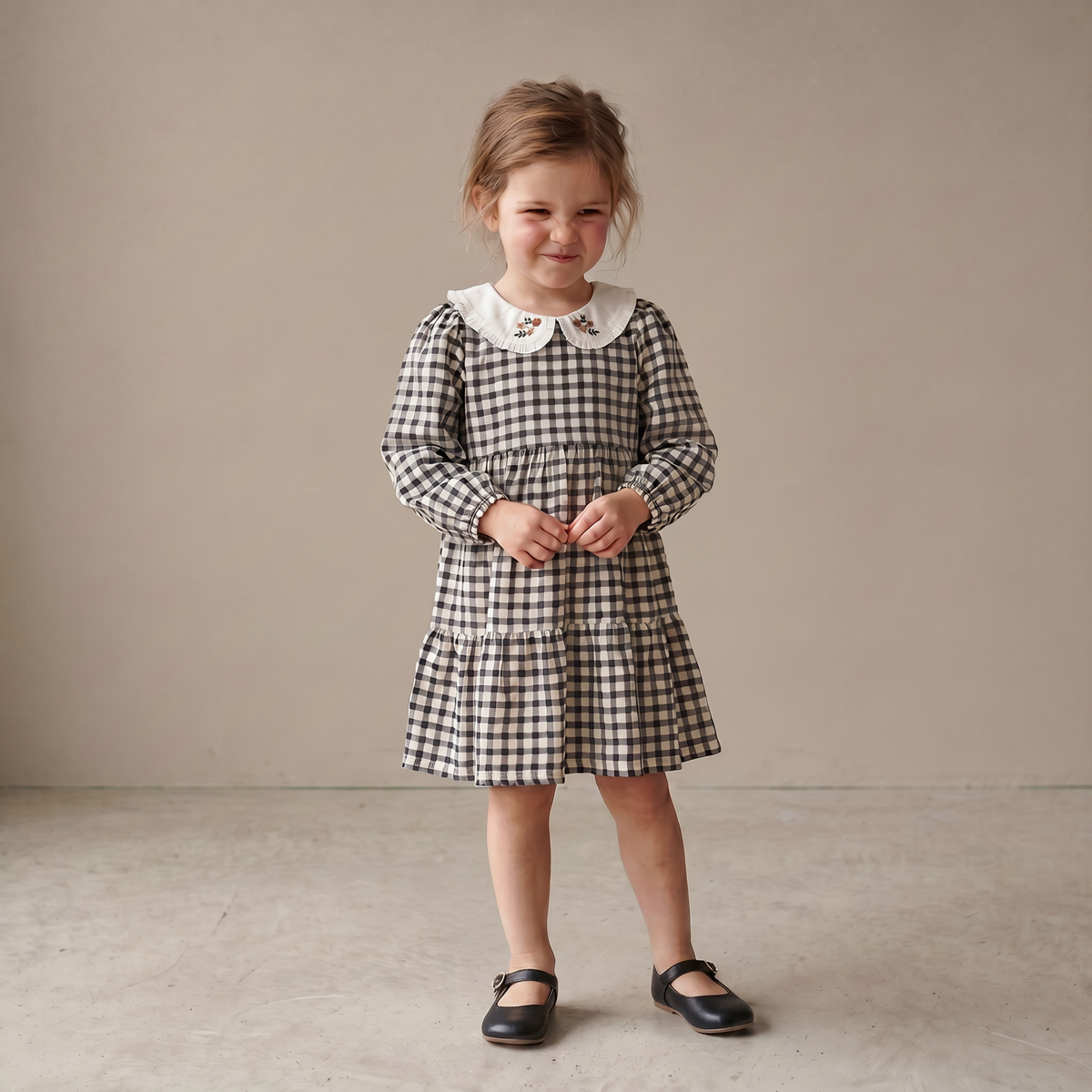 Charcoal plaid tiered baby dress with a collared neckline and gathered tiers