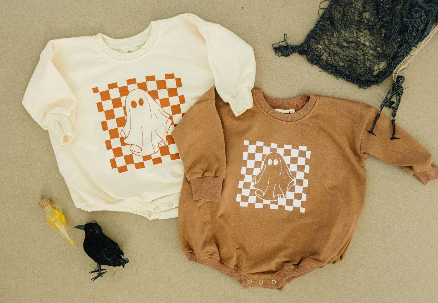 Oversized sweatshirt romper with a retro checkered ghost graphic and snaps at the crotch.
