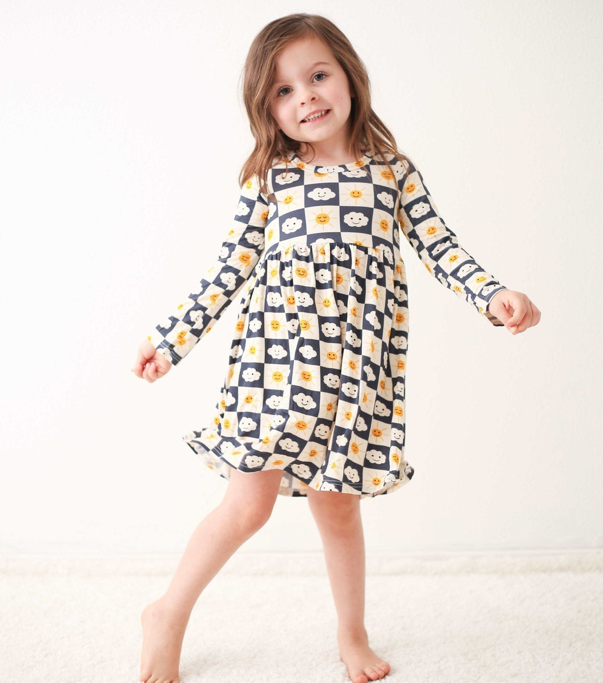 Checkered long-sleeve toddler dress in a small check pattern, worn by a child model