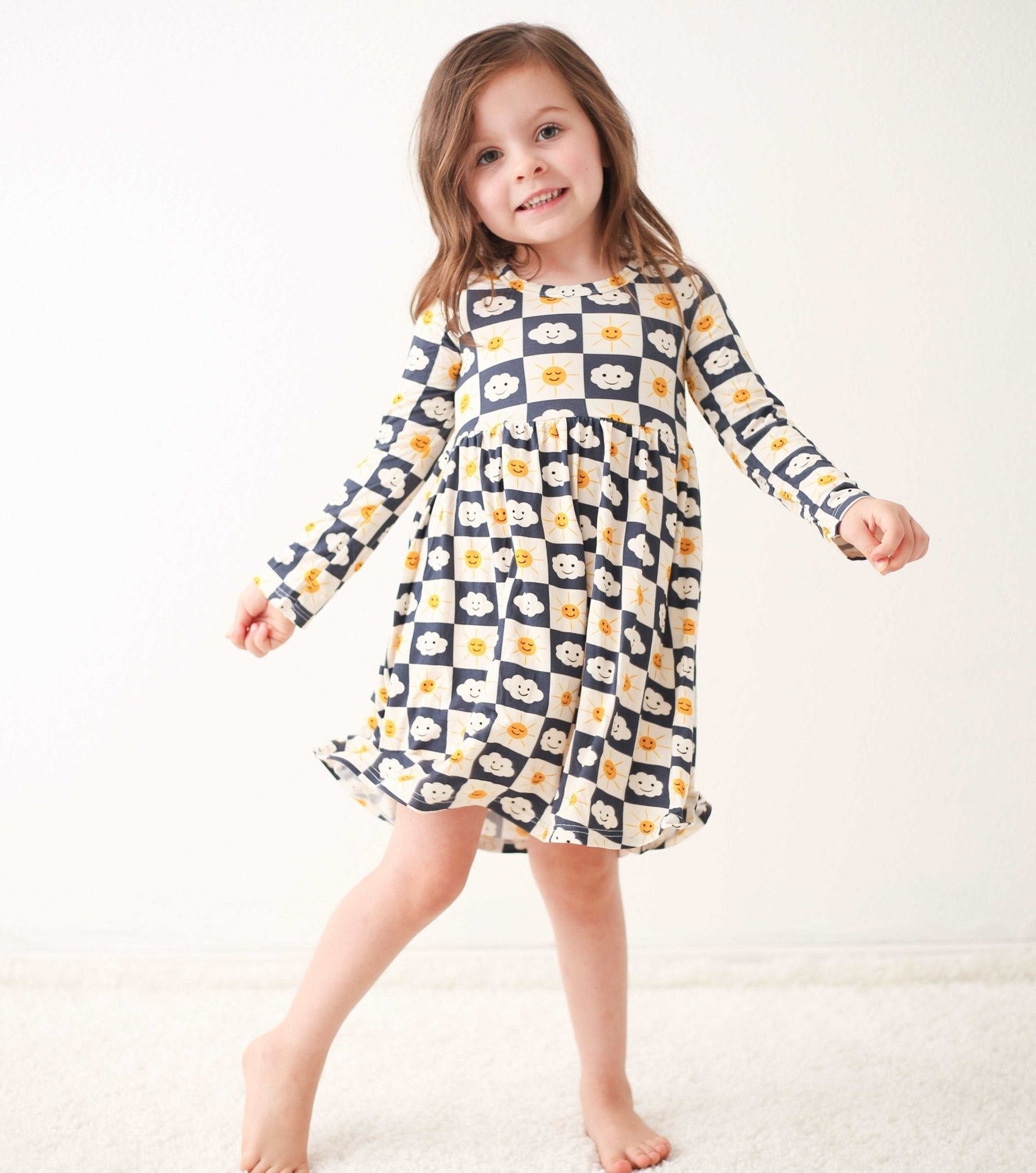 Checkered long-sleeve toddler dress in a small check pattern, worn by a child model