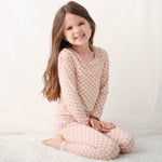 Two-piece baby pajama set with pink checkered pattern, matching long-sleeve top and pants