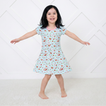 Short sleeve A-line toddler dress in a cherry print, shown flat with a rounded neckline and flared skirt