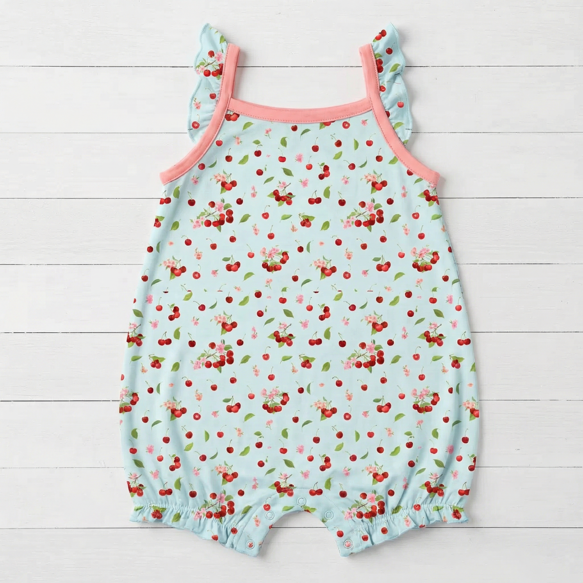 Baby bubble romper with cherry print, flutter sleeves and snap closures along the legs