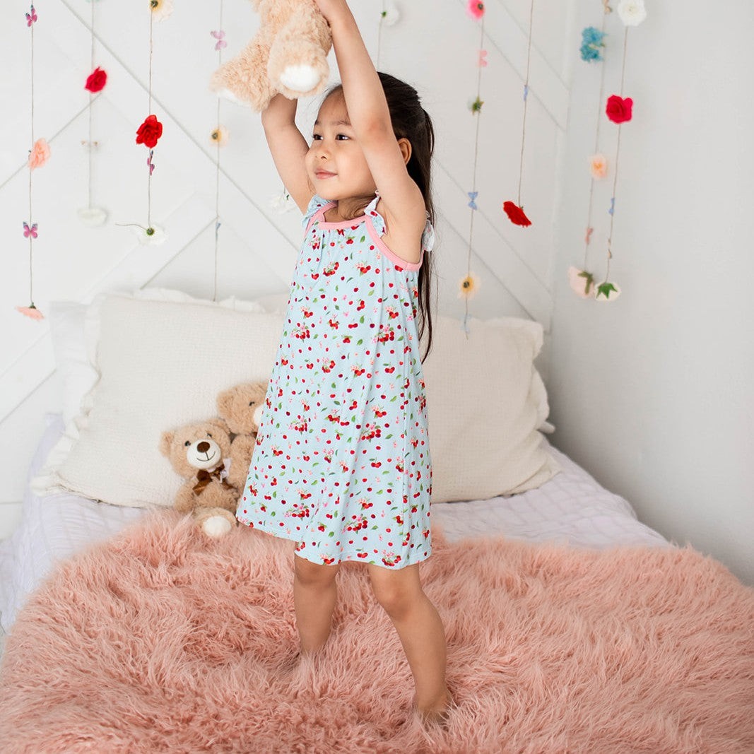 Flutter sleeve dress in a cherry print on a light background, with short ruffled sleeves and a twirl skirt