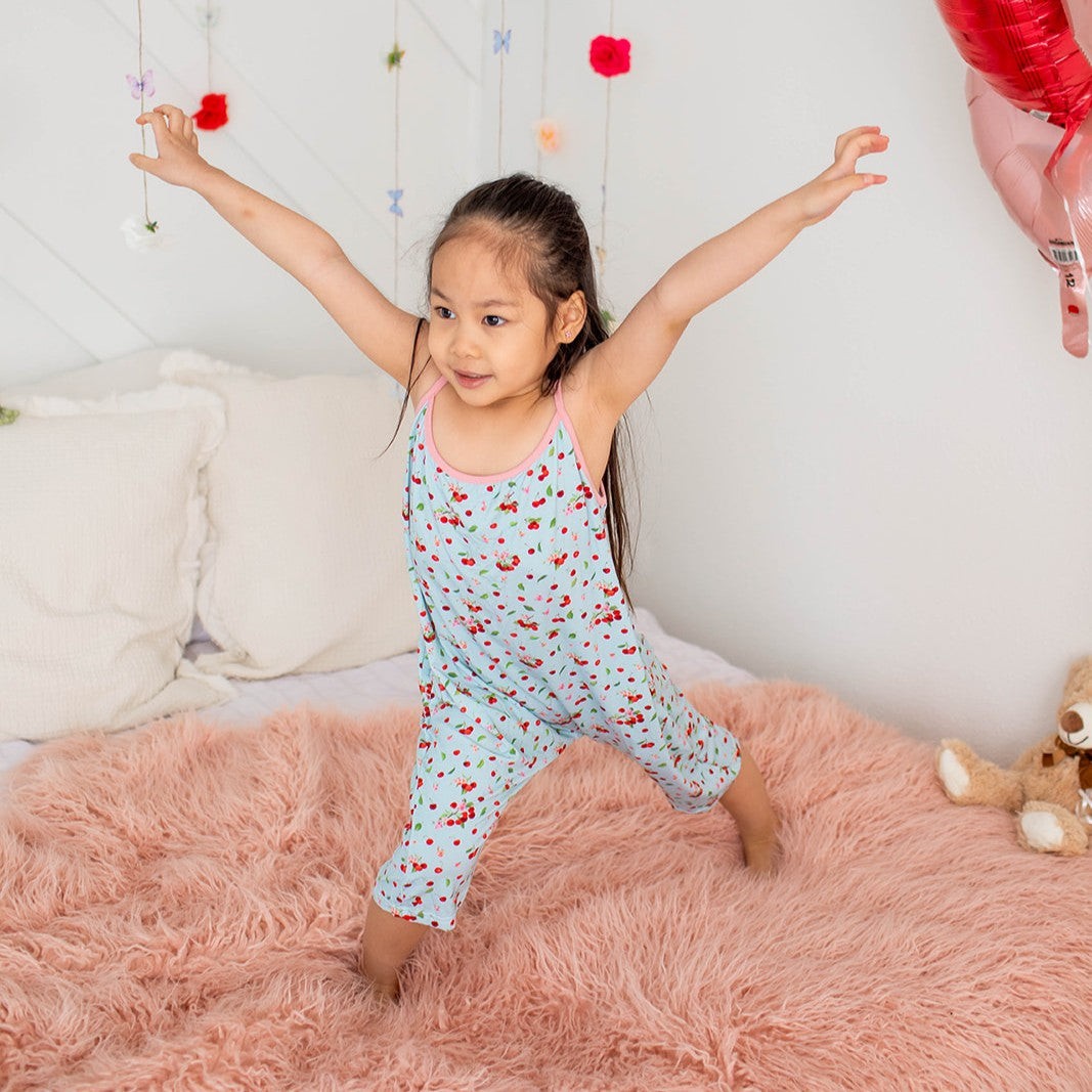 Toddler jumpsuit in cherry print with short sleeves, side pockets and a stretchy round neckline