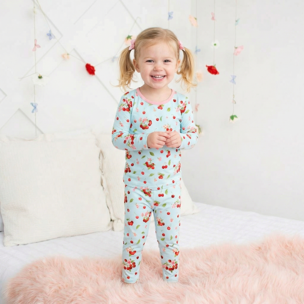 Two-piece long sleeve baby pajama set with cherry print on a light background