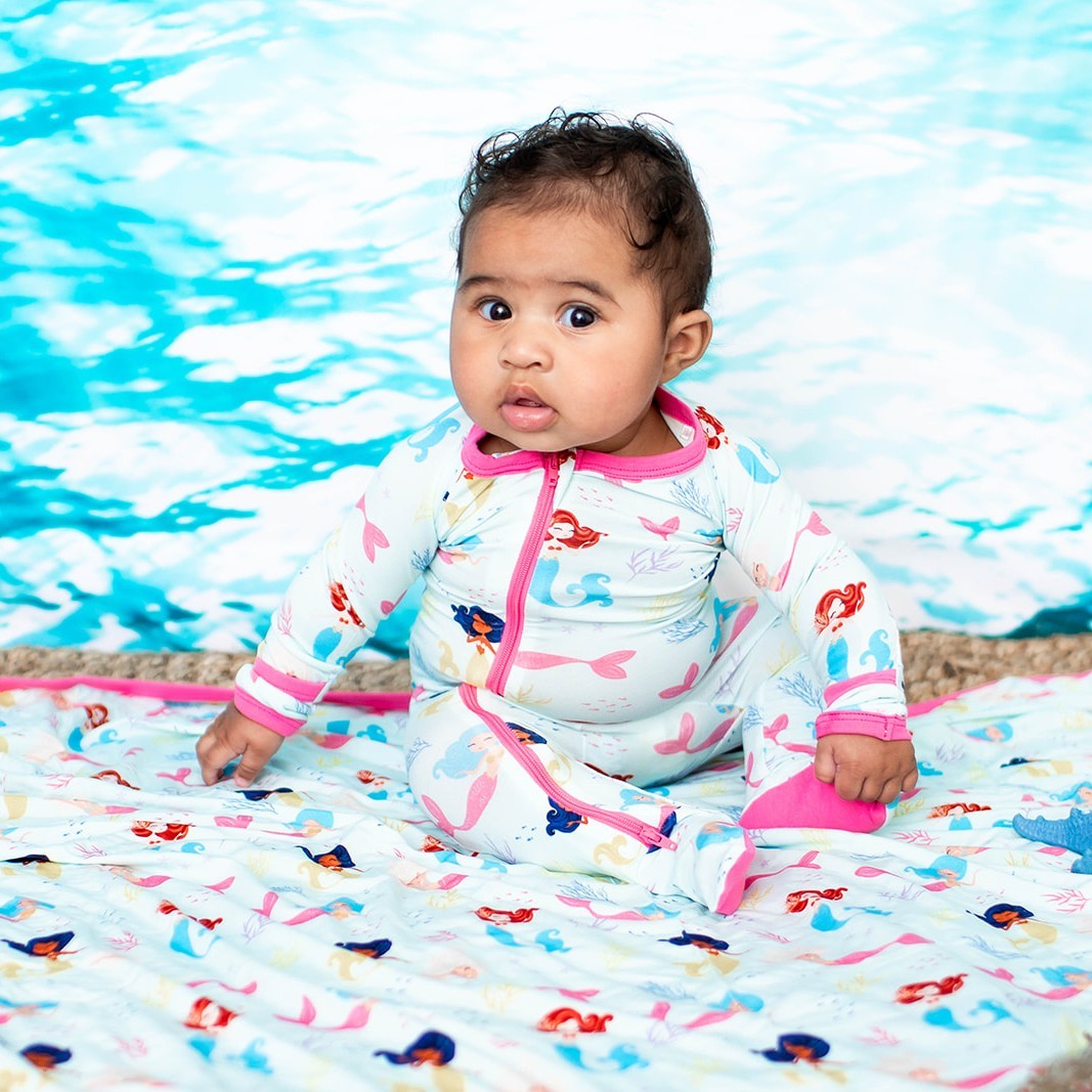 Baby footie pajamas in a coral print with two-way front zipper and covered feet