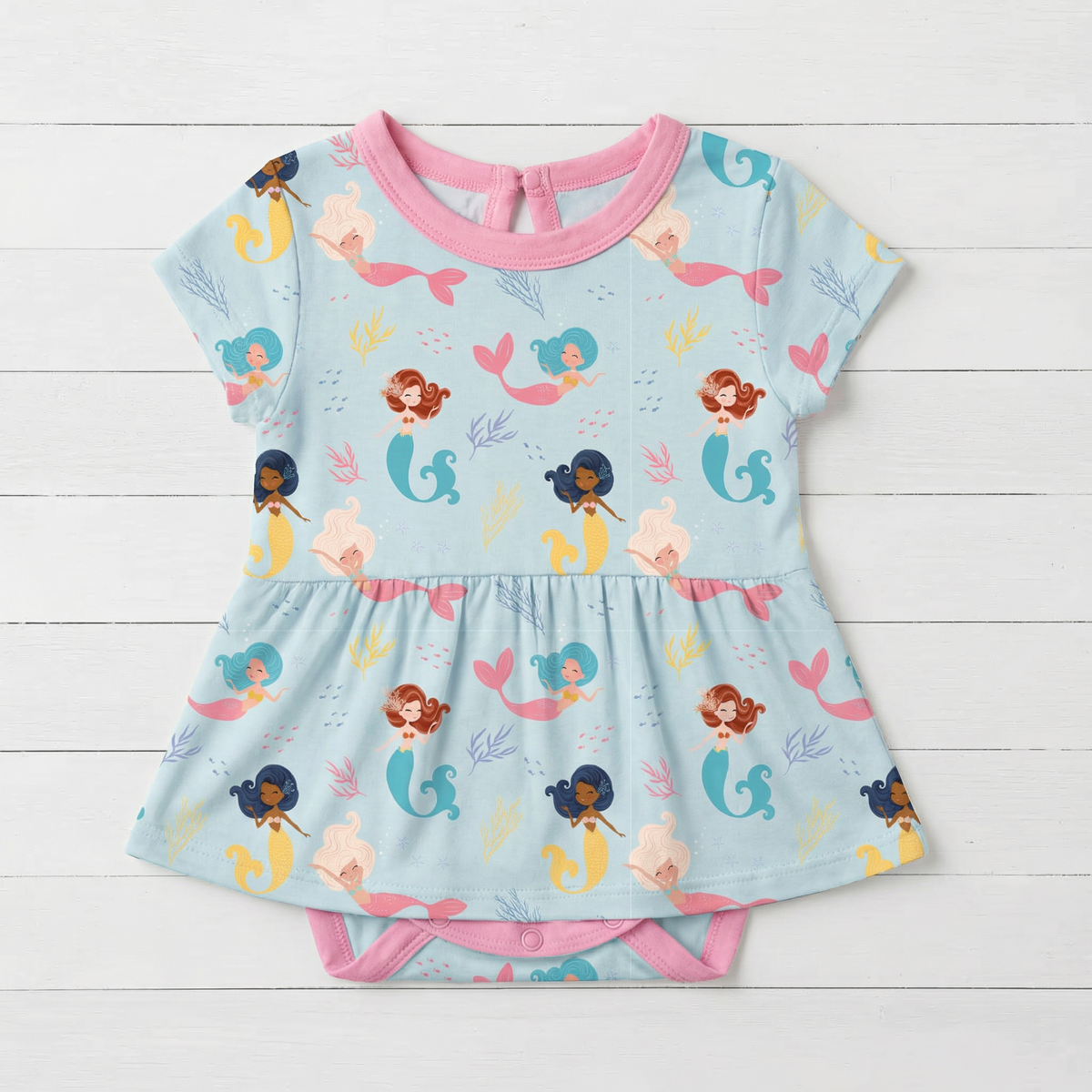 Short sleeve baby bodysuit dress in a coral print with a flared skirt and snaps at the bottom
