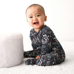 Baby footie pajamas in a dark midnight cosmic print with long sleeves and covered feet
