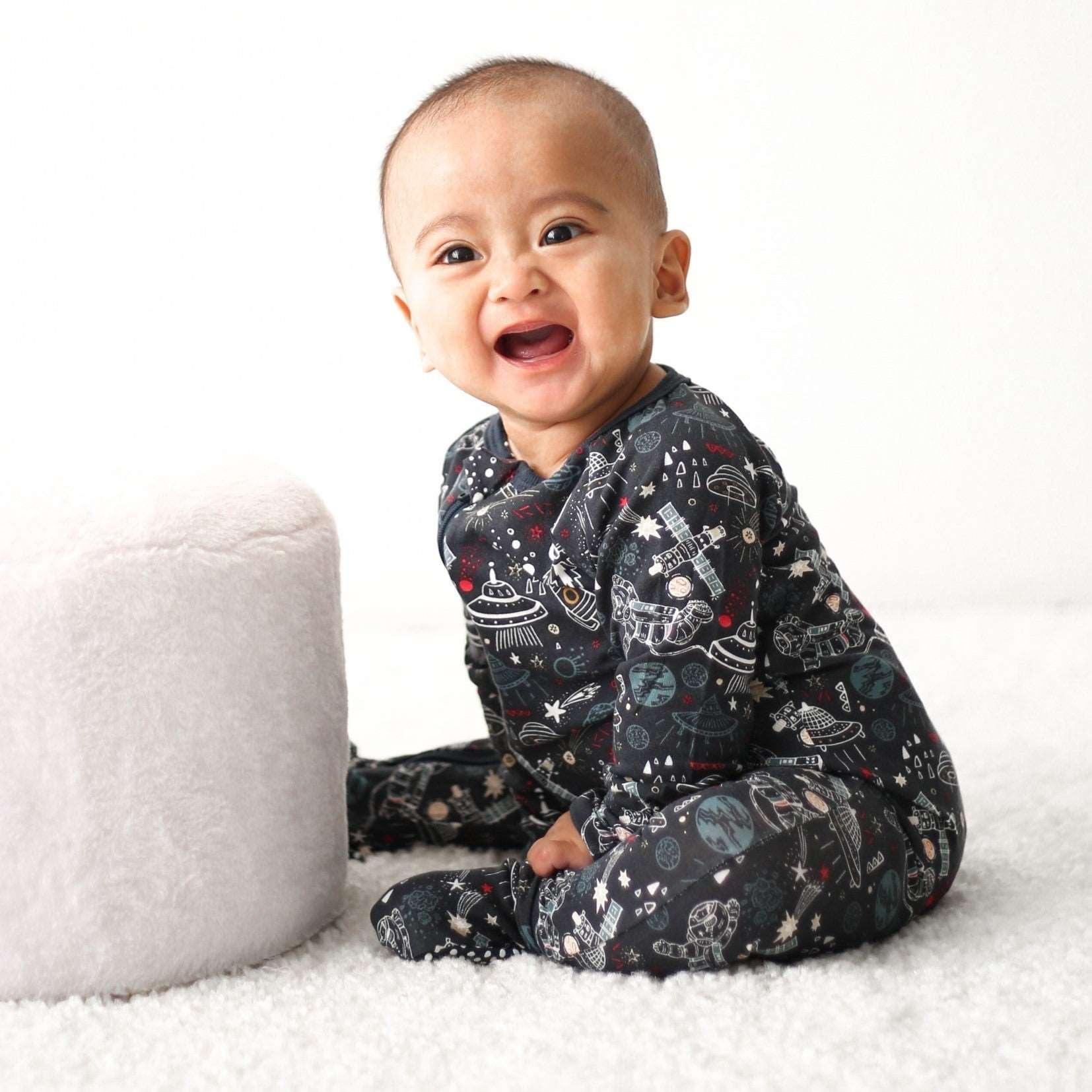Baby footie pajamas in a dark midnight cosmic print with long sleeves and covered feet