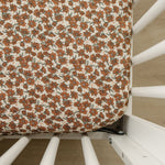 Cream magnolia bamboo stretch crib sheet fitted on a standard crib mattress in a nursery.